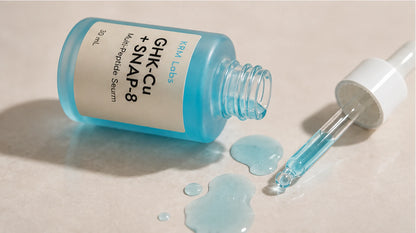 Blue serum bottle with dropper on a beige background