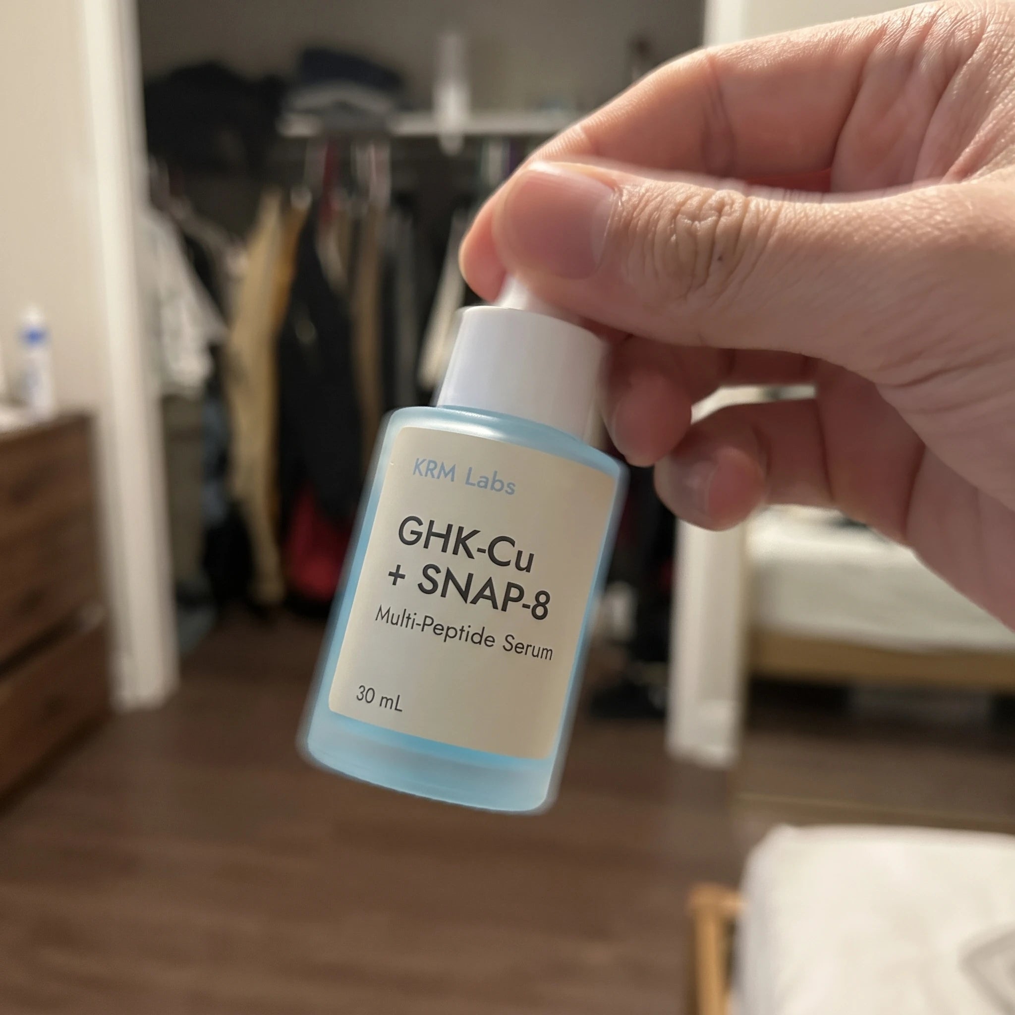 Customer hand holding KRM Labs serum bottle